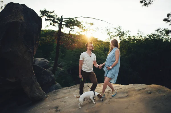 Par njuter av naturen på bergstoppen med hund — Stockfoto