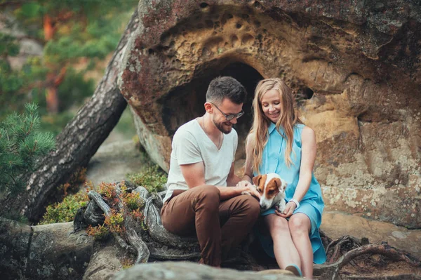 Pár sedí na skále a užívání si přírody se psem — Stock fotografie