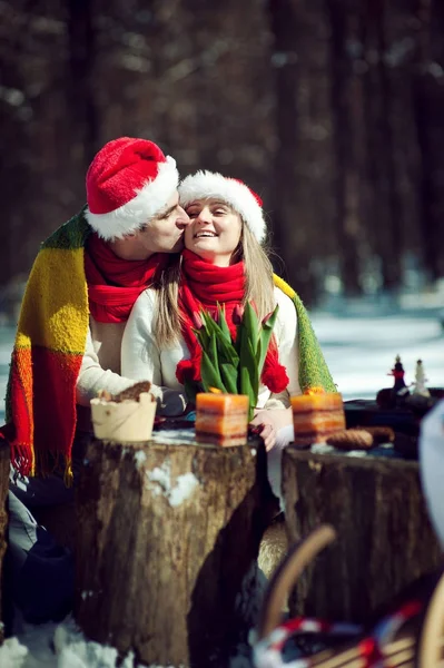Paar in rode hoeden knuffelen op glade — Stockfoto