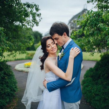 Mutlu şık gelin ve damat yeşil park sarılma gülümseyen