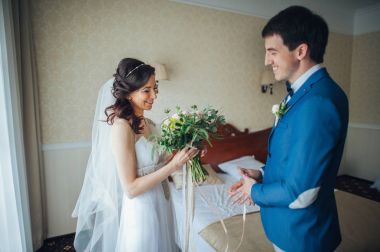 Çiçek ve odada ve birbirine bakarak yaka çiçeği ile damat ile gelin