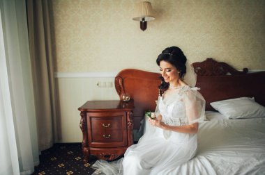 Otel Oda oturan yaka çiçeği ile mutlu gelin gülümseyen