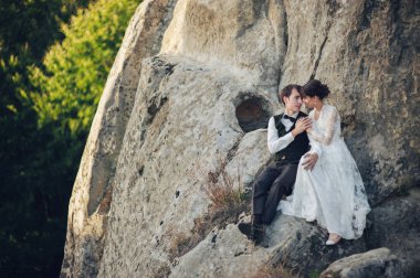 genç çekici beyaz nişanlı çift kaya Dağları'nda el ele tutuşarak