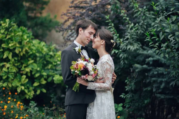 漂亮的高加索订婚情侣与鲜花拥抱在公园 — 图库照片