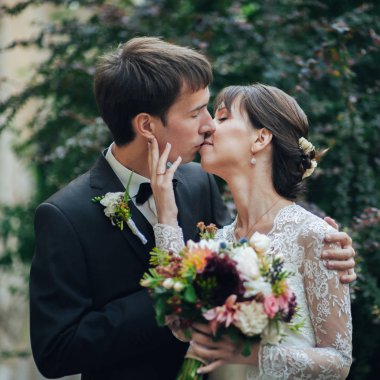 parkta öpüşme buket ile çekici beyaz nişanlı Çift