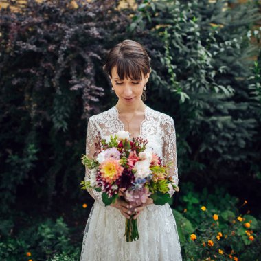 güzel beyaz gelin gelinlik buket doğa arka plan önünde poz ile