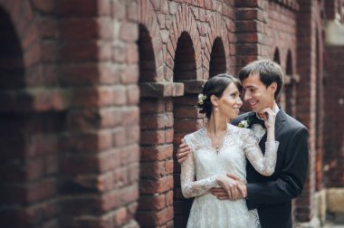 genç çekici beyaz nişanlı çift bina yanında sarılma