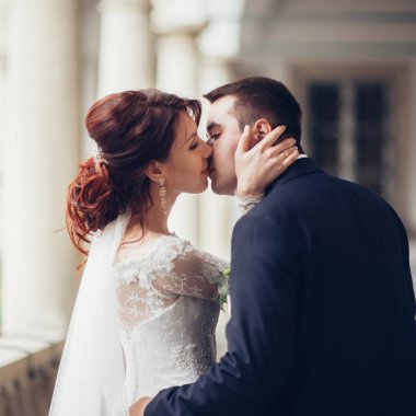 Balkonda öpüşme genç çekici evlilik çift yan görünüm