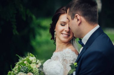 genç çekici beyaz düğün çifti ile parkta sarılma çiçek buketi