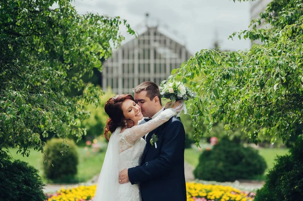 Gelukkig Kaukasische Bruidspaar Met Bloemen Boeket Knuffelen Park — Stockfoto