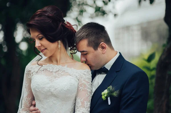 高加索婚礼情侣拥抱在公园 新郎亲吻新娘在肩膀 — 图库照片