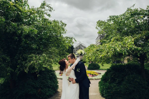 公園でハグの花の花束と結婚式のカップル — ストック写真