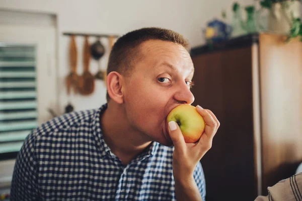Man eating apple from female hand