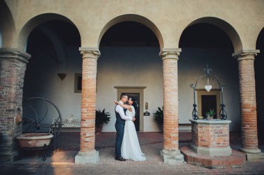 Yeni nikahlı çift eski binanın önünde sarılma