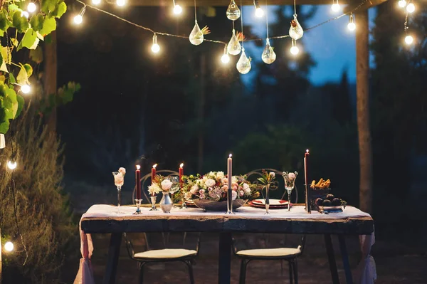 Meja Pernikahan Luar Ruangan Dihiasi Dengan Bunga Lampu Dan Lilin Stok Gambar