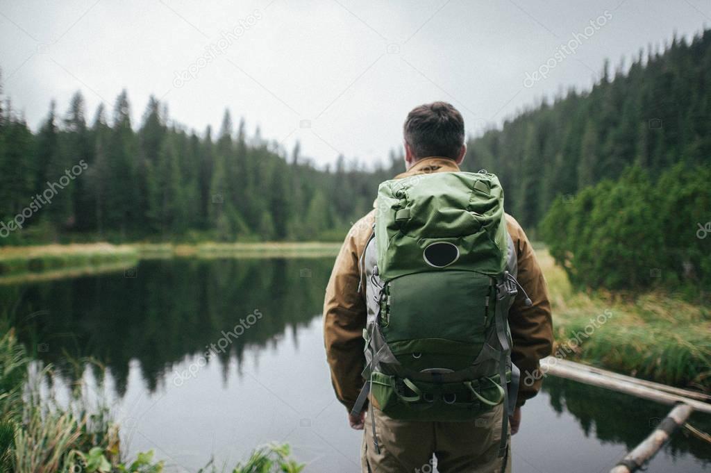 Man looking on scenic view of mountain lake and forest