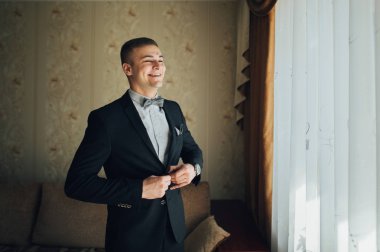 Hazırlama ve düğün töreni önce kamera poz gülümseyen damat