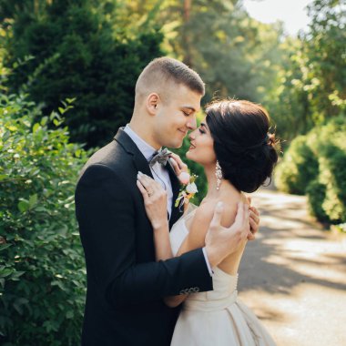 Yeni nikahlı çift parkta ağaçların arasında sarılma