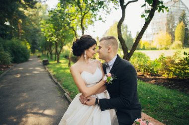 Yeni nikahlı çift parkta ağaçların arasında sarılma