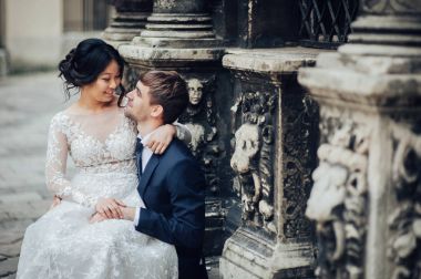 Yeni nikahlı çift yakınındaki antik duvar sütunlarla poz