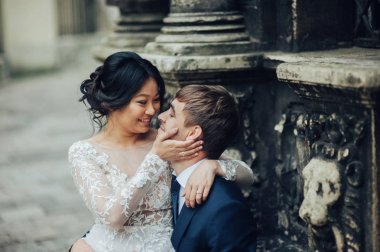 Yeni nikahlı çift yakınındaki antik duvar sütunlarla poz