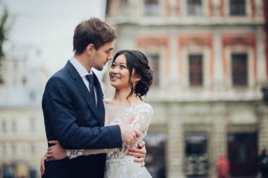 Beyaz elbiseli şefkatle sarılma Asya gelin damat