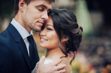 Beyaz elbiseli şefkatle sarılma Asya gelin damat