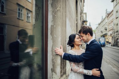 Yeni nikahlı çift eski püskü duvara yakın poz