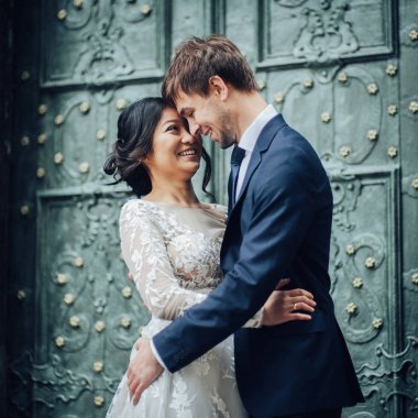 Yeni nikahlı çift antika yeşil kapının yanında poz