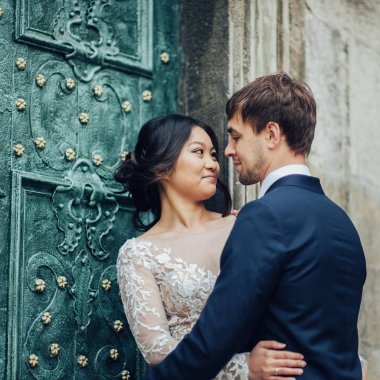 Yeni nikahlı çift antika yeşil kapının yanında poz