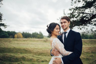 Bulutlu günde açık poz Asya gelin ile damat