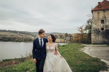 Gelin ile damat Gölü kıyısında yürüme zarif gelinlik