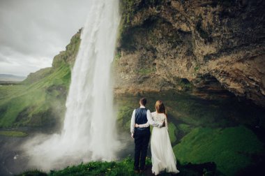 Evli çiftin şelale yürüyüş arkadan görünüş 