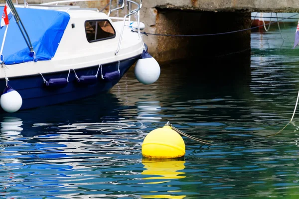 Blå og hvit motorbåt med gul bøye – stockfoto