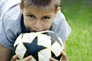 Stadyumun arka planı elinde bir futbol topu ile genç çocuk.