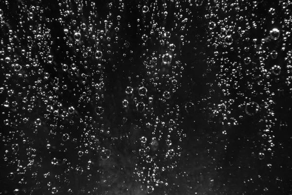 Gotas de lluvia sobre el vidrio sobre un fondo negro — Foto de Stock