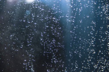 Mavi bir arka plan üzerinde camına yağmur damlaları