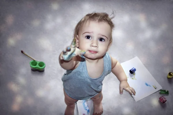 Aranyos kisfiú a kezét piszkos festékek mutatja az ujját a kamera — Stock Fotó