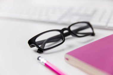 Okuma gözlükleri ve office çalışma üstünde defter
