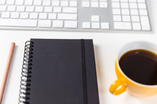 Cuaderno de café y teclado en la mesa de la oficina — Foto de Stock