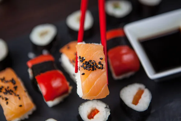 Sushi retenido en palillos —  Fotos de Stock