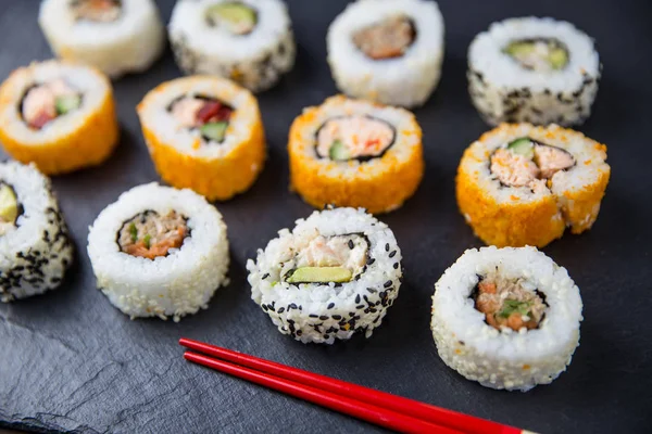 Rollos de sushi con palillos rojos —  Fotos de Stock