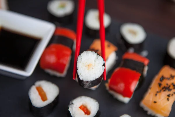 Sushi retenido en palillos —  Fotos de Stock