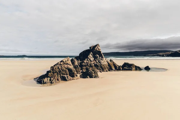 Rocks on sandy beach Stock Image
