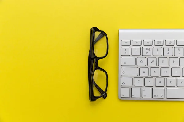 Teclado y gafas de lectura —  Fotos de Stock