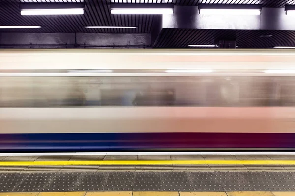 Tåg i rörelse anländer till plattform — Stockfoto