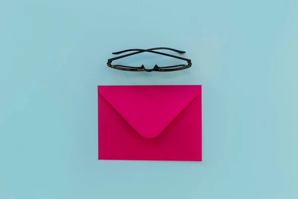 Pink envelope with eyeglasses — Stock Photo, Image