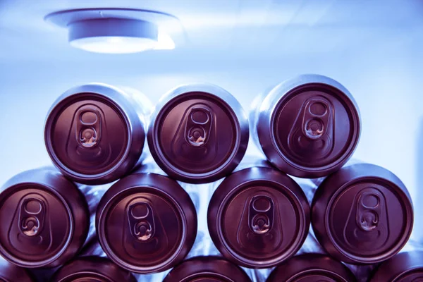 Cold soda drinks metal cans in fridge at night