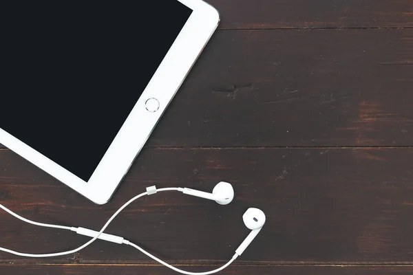 Beyaz Tablet Bilgisayar Müzik Kulaklık Koyu Kahverengi Masa Arka Plan — Stok fotoğraf