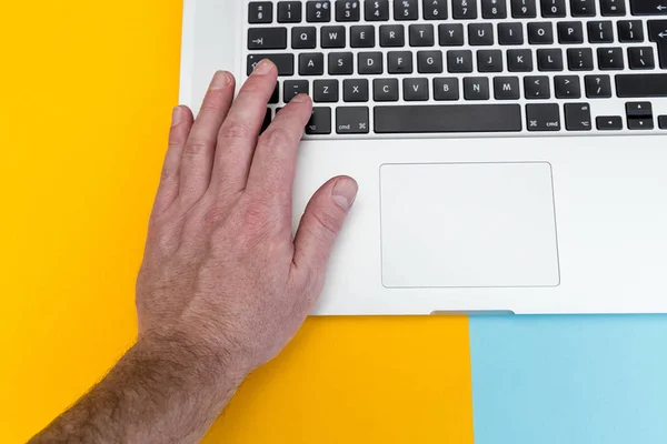 Männerhand Tippt Auf Laptop Computertastatur Über Kopf Auf Leuchtend Gelbem — Stockfoto